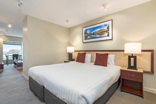 a hotel room with a bed and a television at Mantra One Sandy Bay Road in Hobart