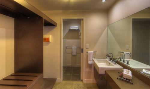 La salle de bains est pourvue d'un lavabo, d'une baignoire et d'un miroir. dans l'établissement Sovereign Resort Hotel, à Cooktown