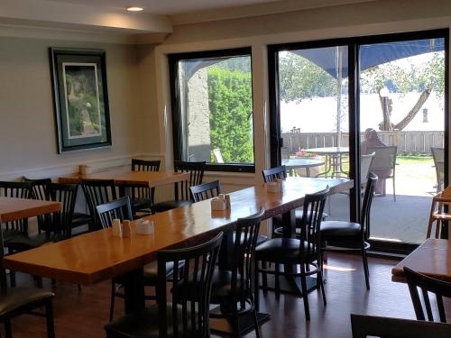 a restaurant with wooden tables and chairs and windows at Inn on Long Lake in Nanaimo