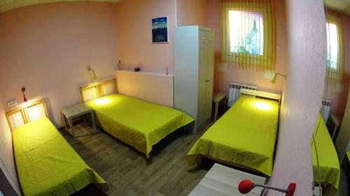 ノヴォシビルスクにあるHostel On-dayのベッド2台(緑のシーツ付)が備わる客室です。