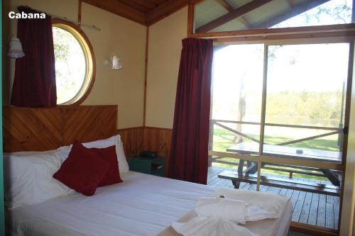 a bedroom with a bed and a large window at Lani's Holiday Island in Forster