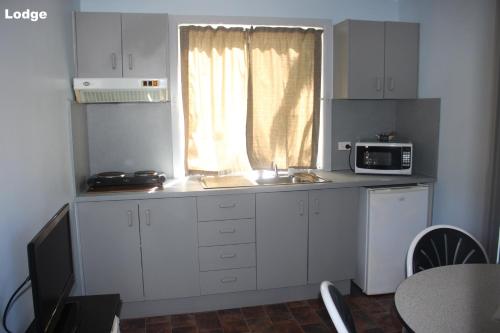 a small kitchen with a sink and a microwave at Lani's Holiday Island in Forster