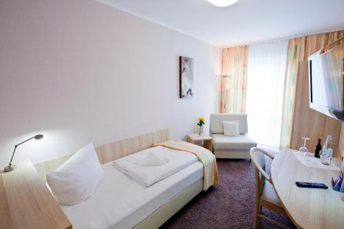 a hotel room with a bed and a table at Hotel Siebenschläfer in Alsdorf