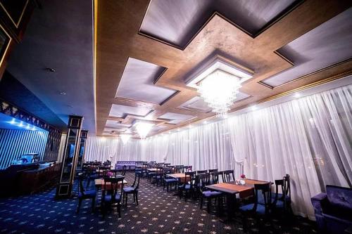 a dining room with wooden tables and chairs at Hotel Ten Constanta in Constanţa