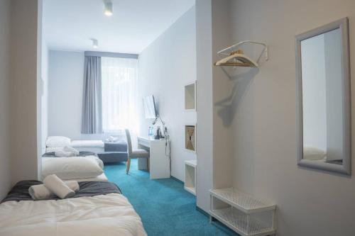 a hotel room with two beds and a mirror at Hotel Inner City in Kutno