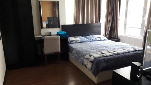 ein Schlafzimmer mit einem Bett und einem Schreibtisch mit einem Stuhl in der Unterkunft STUDIO ROOM at BAYOULAGOON RESORT, MELAKA in Malakka