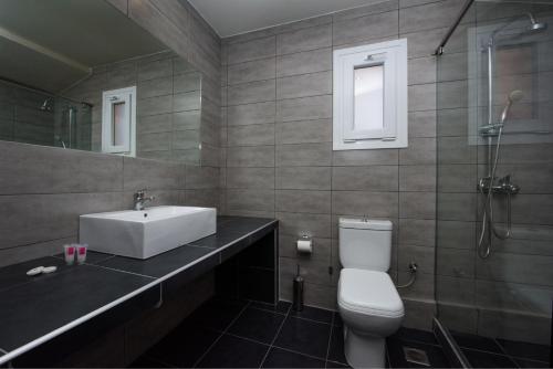 a bathroom with a sink and a toilet at Olympion Village in Kavos