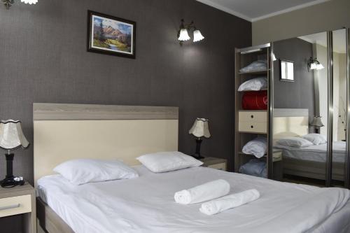 a bedroom with a bed with white sheets and pillows at Hotel Orbi Plaza in Batumi