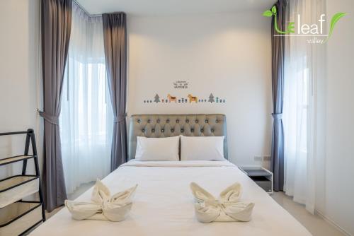 a bedroom with a bed with two white flowers on it at Le Leaf Valley Hua Hin 29 in Hua Hin