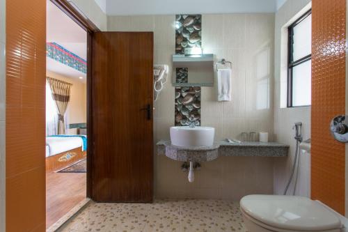 a bathroom with a toilet and a sink in it at Hotel Yukhang in Kathmandu