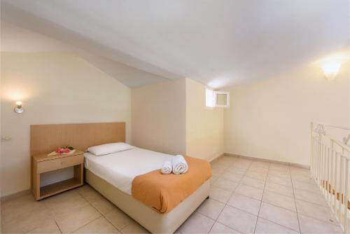 a bedroom with a bed with two towels on it at Olympion Village in Kavos