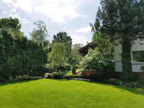 podwórko z domem i zielonym trawnikiem w obiekcie Pokój w Warszawie-Wawer w Warszawie