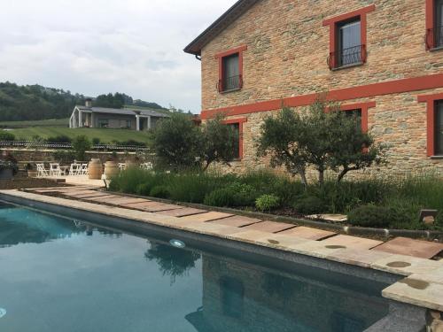a house and a swimming pool next to a building at Agriturismo La Ratta in Vernasca