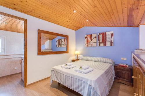 ベグールにあるFlateli Begur Apartmentの木製の天井が特徴のベッドルーム1室(ベッド1台付)