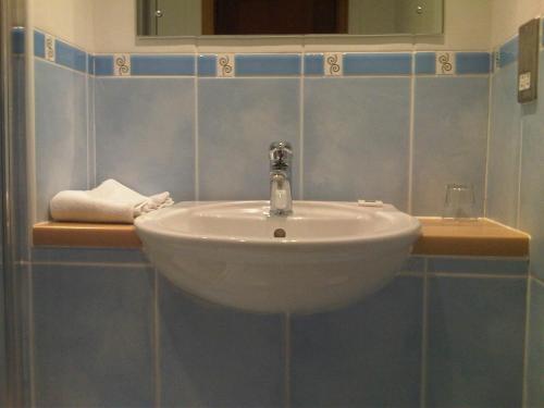 a white sink in a bathroom with blue tiles at Sky Lodge Perth in Perth