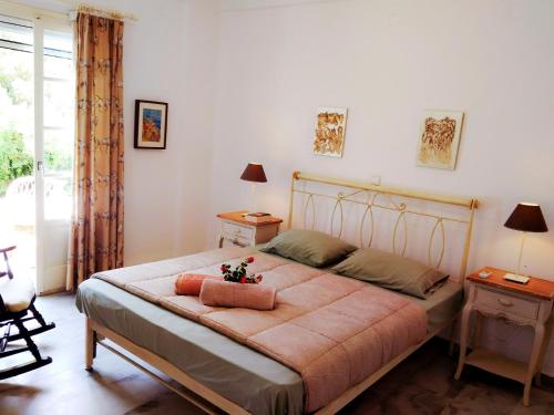 a bedroom with a large bed with two tables and two lamps at Villa Kavalli Paros in Prodromos Paros