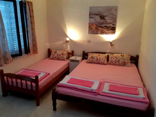 two beds in a room with pink sheets at Apartments Ceca in Tivat