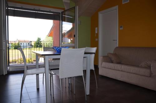 a dining room with a table and chairs and a couch at Eco-Residence in Casale Monferrato