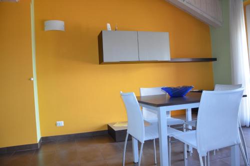 a dining room with a table and white chairs at Eco-Residence in Casale Monferrato