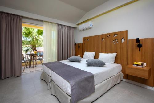 a bedroom with a large bed and a balcony at Olympion Village in Kavos