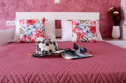 a bed with a hat and a pair of glasses on it at George's Place in Ios Chora