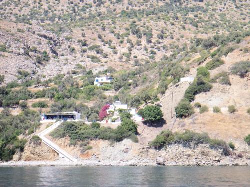 a house on a hill next to the water at Nikos Place in Agia Galini