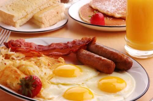 a plate of breakfast food with eggs bacon and toast at Moffat Court Boutique Hotel in Mombasa