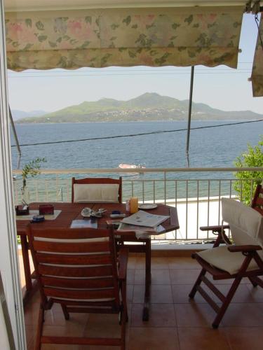 a table and chairs on a balcony with a view of the ocean at Glaros Studios in Loutra Edipsou
