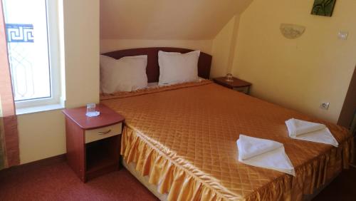 a bedroom with a bed with two pillows on it at Family Hotel Mimosa in Tsarevo