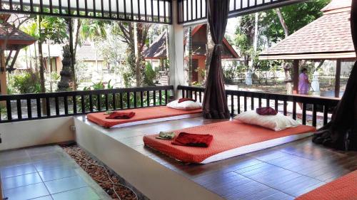 two beds in a room with a balcony at Koh Mook Sivalai Beach Resort in Ko Mook