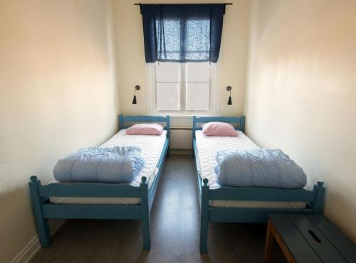 2 camas en una habitación pequeña con ventana en Hostel Utö, en Utö