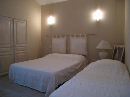 a bedroom with two beds and two lights on the wall at Le Clos Olives in Comps