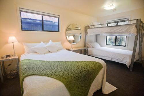 a bedroom with two bunk beds and a mirror at Tyenna River Cottages in Tyenna