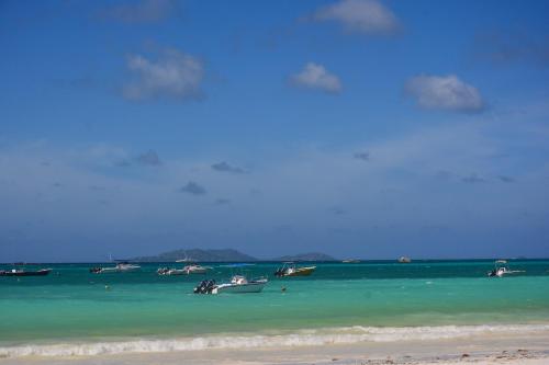 a group of boats in the water on a beach at Berjaya Praslin Resort in Anse Volbert Village