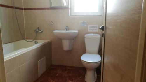 y baño con aseo y lavamanos. en Family Hotel Mimosa, en Tsarevo