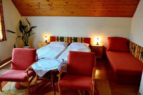 1 dormitorio con 1 cama, 2 sillas y sofá en Penzion Alfa Tatry, en Stará Lesná