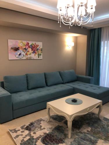 a living room with a blue couch and a coffee table at Luxury Apartment Sophia 3 - DaviDary in Mamaia