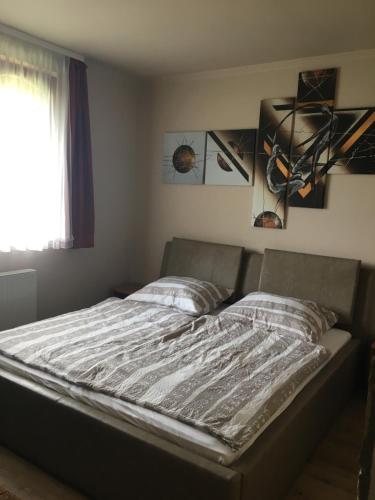 a bed in a bedroom with posters on the wall at Holiday Vendégház in Siófok