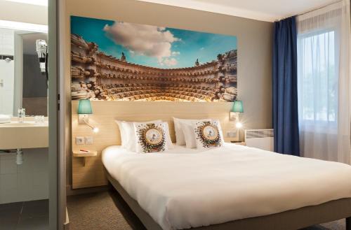 a hotel room with a large bed and a sink at The Originals City, Tabl'Hôtel, Amiens in Longueau