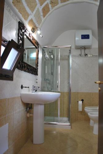 y baño con lavabo y ducha acristalada. en Casa Vacanza - Antico Attico, en Monteroni di Lecce