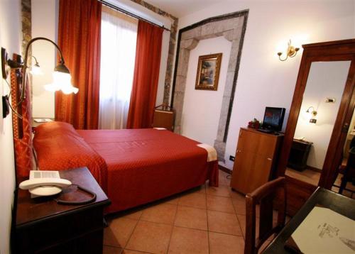 a hotel room with a red bed and a desk at Hotel Villa Sonia in Taormina