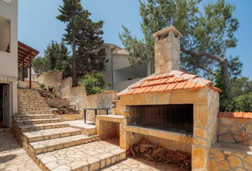 an outdoor pizza oven with stairs in front of a house at Apartments Habek in Vrboska