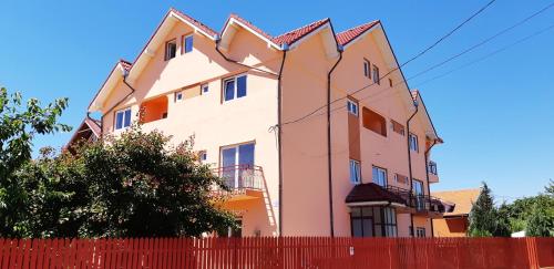 a pink house behind a red fence at Vila Tropical in Costinesti