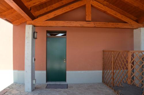 a green door in a building with a wooden ceiling at Eco-Residence in Casale Monferrato