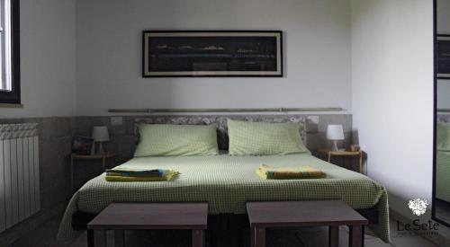 um quarto com uma cama grande e duas mesas em Le Sete em Bari