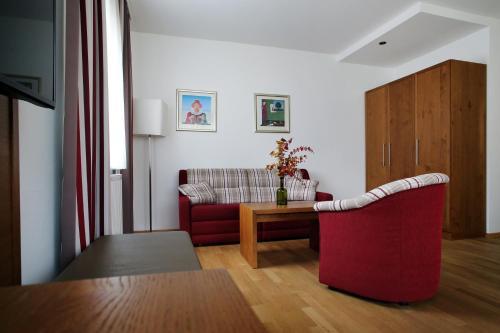 a living room with a red couch and a table at Landgasthof Barenwirt in Petzenkirchen