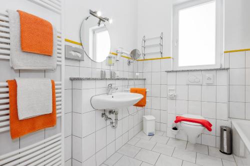 a white bathroom with a sink and a toilet at Apart Hotel Stadtgarten in Überlingen