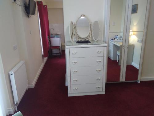 a room with a dresser with a mirror on it at The Great Western B&B in Paignton