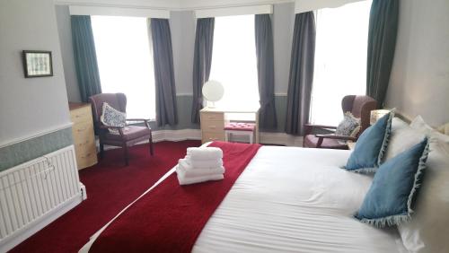 a bedroom with a large white bed with blue pillows at The Great Western B&B in Paignton