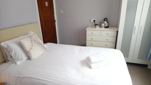 a bedroom with a white bed with two pillows at The Great Western B&B in Paignton